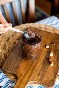 Close-up of hand holding chocolate drink on table