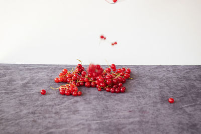 Red berries on table against white background