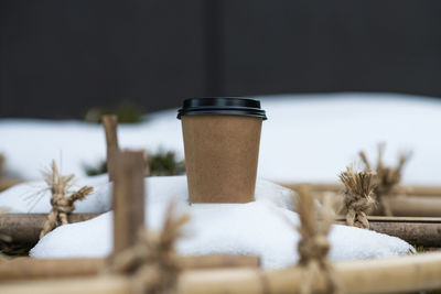 Close-up of disposable coffee cup on snow