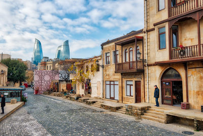 Buildings in city against cloudy sky