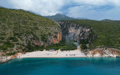 Scenic view of sea and mountains against sky