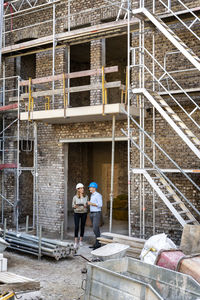 Businesswoman with digital tablet working with colleague at construction site