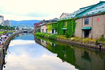 Reflection of houses in lake against sky