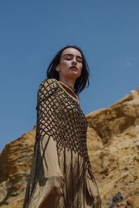 Low angle view of woman standing against clear sky