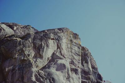 Low angle view of rock formation against clear blue sky