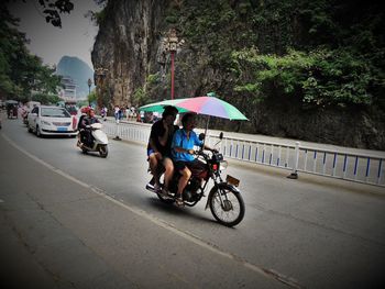 People riding bicycle on road in rain