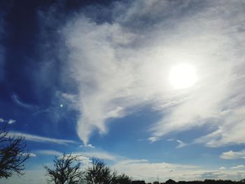 Low angle view of sunlight streaming through clouds