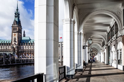 View of building corridor next to river against cloudy sky