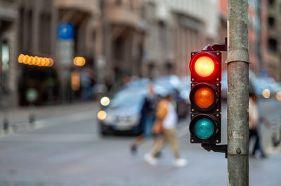 A city crossing with a semaphore on blurred background with cars in the evening streets, red light