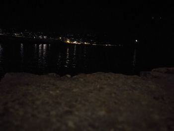 Illuminated beach against sky at night