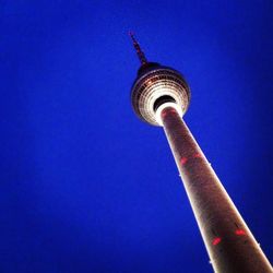 Low angle view of fernsehturm tower against blue sky