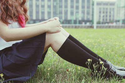Low section of woman sitting on grass