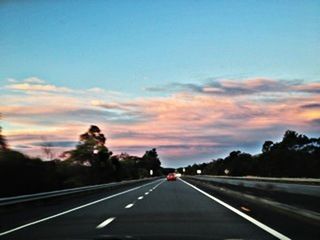 transportation, road, the way forward, road marking, sky, diminishing perspective, vanishing point, cloud - sky, car, sunset, mode of transport, land vehicle, country road, highway, dividing line, cloud, street, on the move, dusk, empty