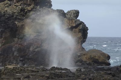 Scenic view of rocks in sea against sky