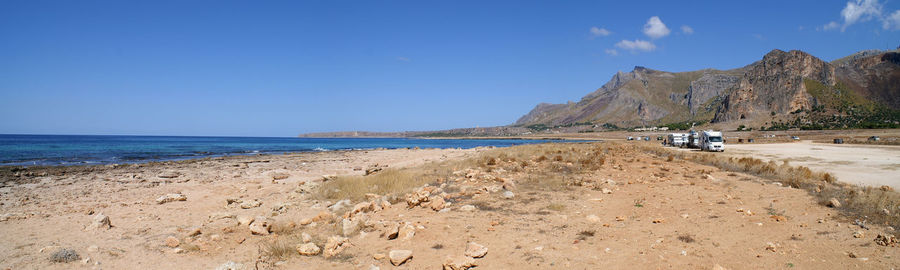 Scenic view of beach against clear blue sky