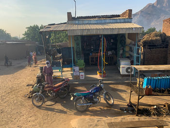 Bicycles on street by buildings against sky