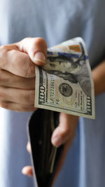 A girl holding one-hundred-dollar bill in her hands