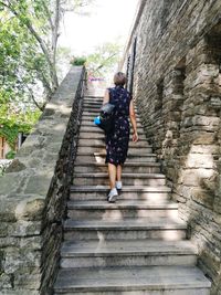 Rear view of woman walking on stairs