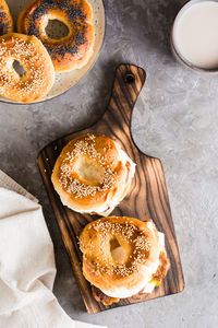 Bagels sandwiches with cheese, fried meat and poached egg on a board on the table. 