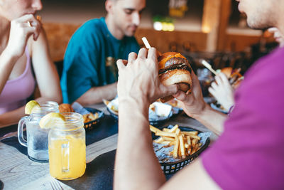 Cheerful friends having fun in fast food cafe