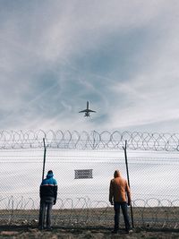 Two men standing near fence