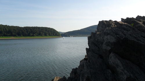 Scenic view of sea and mountains against sky