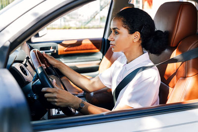 Side view of a woman sitting in car