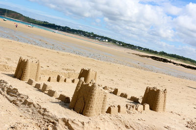 Tilt image of sandcastle at beach against sky