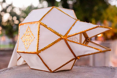 Close-up of white paper lantern with gold edging.