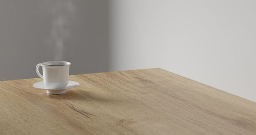 High angle view of coffee cup on table against wall
