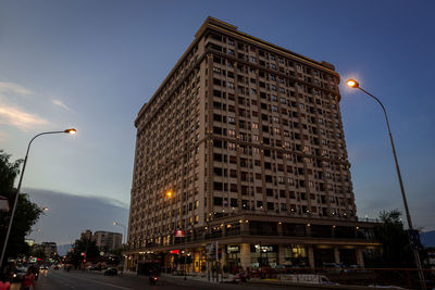 City street and buildings against sky at dusk