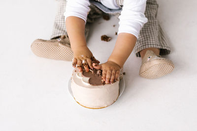 Trendy korean dessert bento cake beige color will be crushed in the hands of a small child