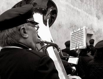 Rear view of senior man playing trumpet during parade