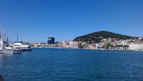 Boats in sea against clear sky