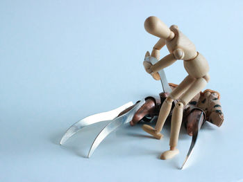 Close-up of figurine on table against white background