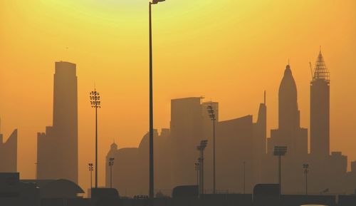 Modern buildings against sky during sunset