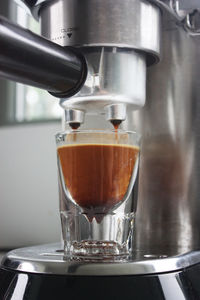 Close-up of pouring coffee in glass at cafe