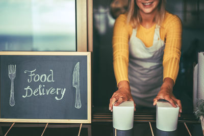 Woman standing by coffee cup