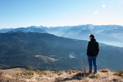 Rear view of woman standing on mountain landscape