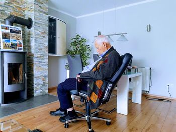 Man and woman sitting on chair at home