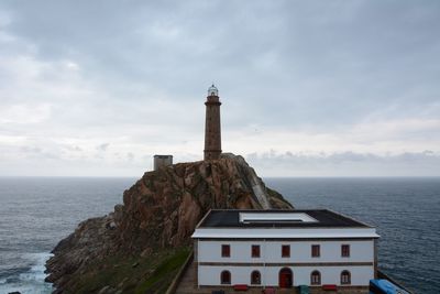 Lighthouse in sea against sky