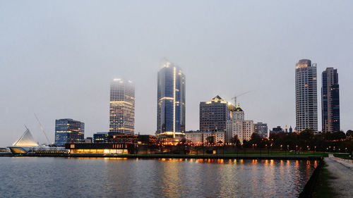 City at waterfront against clear sky