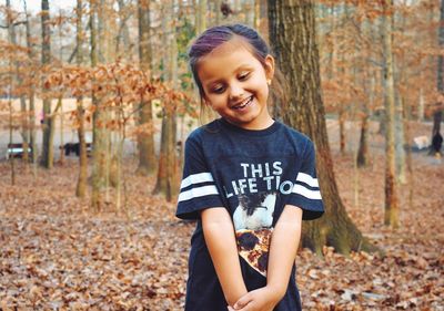 Smiling girl standing on field during autumn