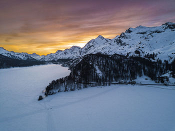 Scenic view of snowcapped mountains against sky during sunset