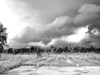 Scenic view of field against cloudy sky