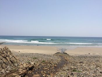 Scenic view of beach against clear sky