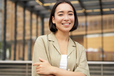 Portrait of young woman standing in city