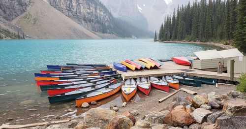 Boats moored on lake against mountain