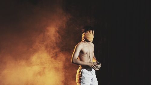 Male performer holding incense sticks on stage