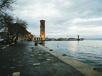 Pier on sea against cloudy sky